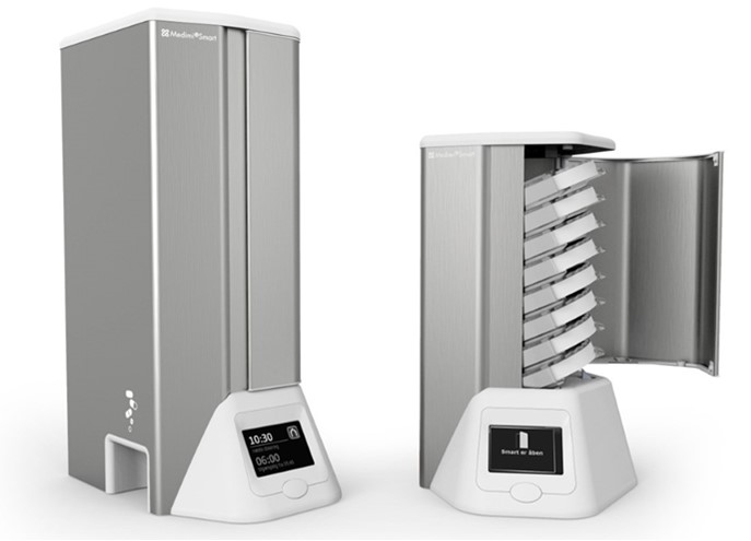 billede af MedimiSmart medicinhusker - er høj og metalfarvet med en hvid fod, hvor der er en lille skærm.