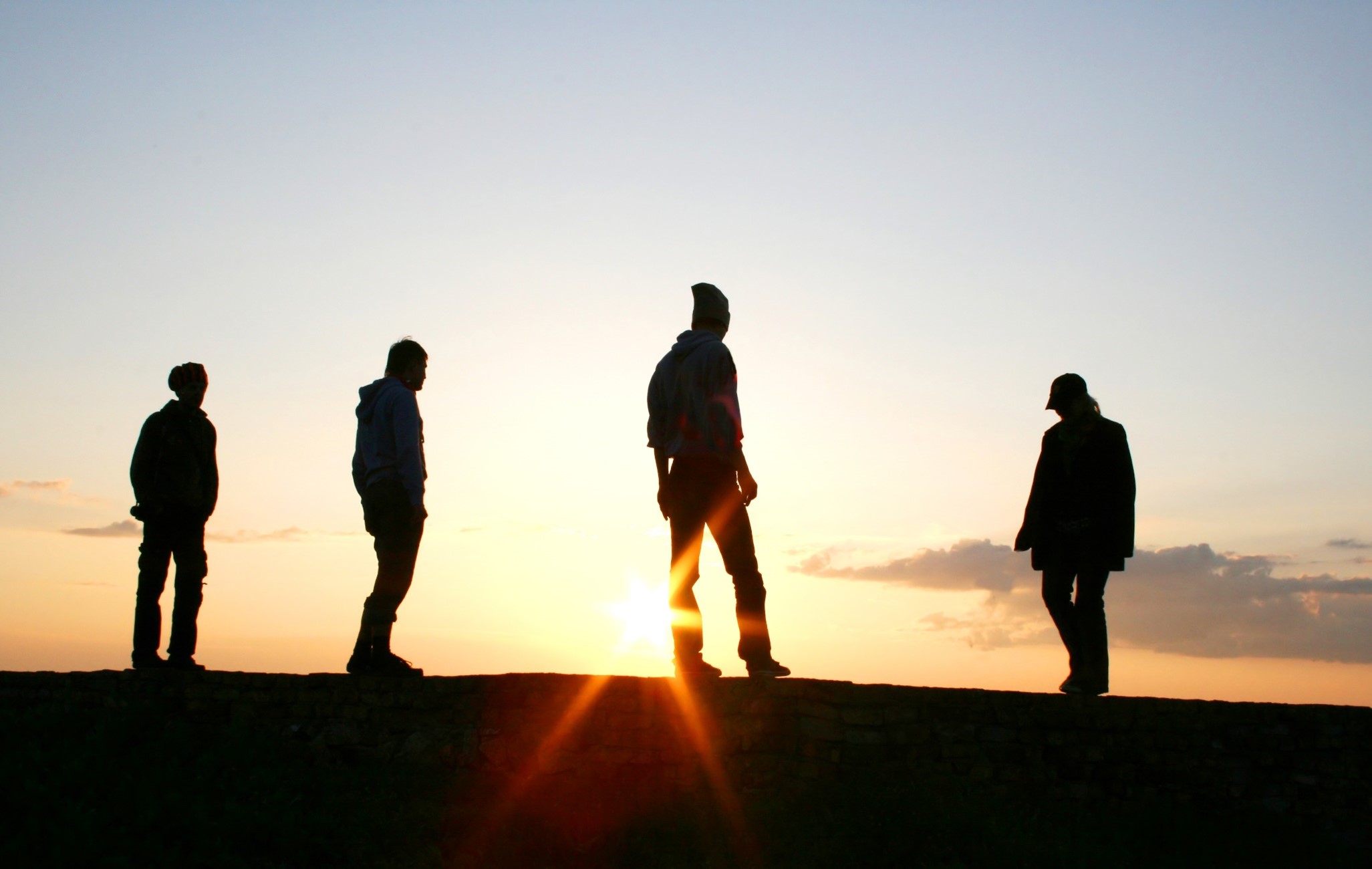 mænd som står i en solnedgang