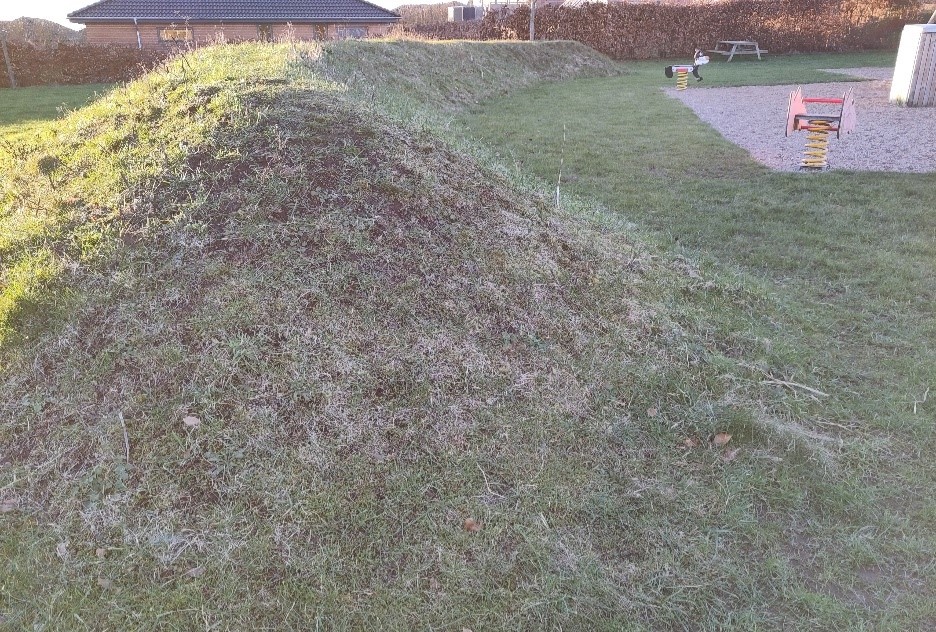 Forhøjning i græsplæne med solside og skyggeside